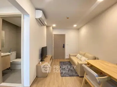 Modern living room with cozy sofa, TV, and dining area in a stylish apartment.