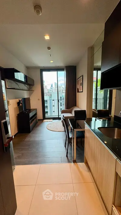 Modern studio apartment with open layout and city view, featuring sleek kitchen and cozy living area.