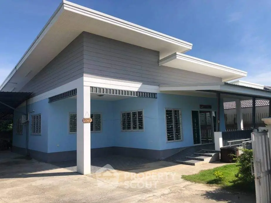 Modern single-story house with blue exterior and sleek roof design, perfect for family living.