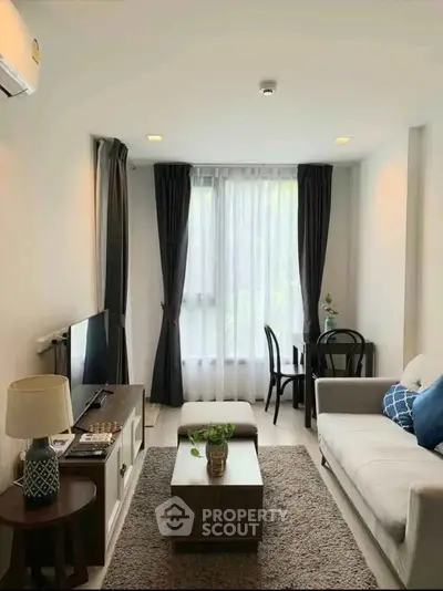 Charming living room with modern decor, cozy seating, and natural light from large window.