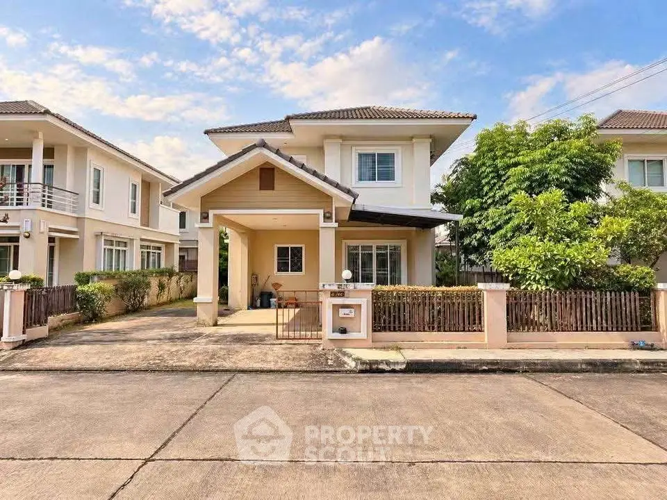 Charming two-story suburban house with driveway and lush greenery, perfect for family living.