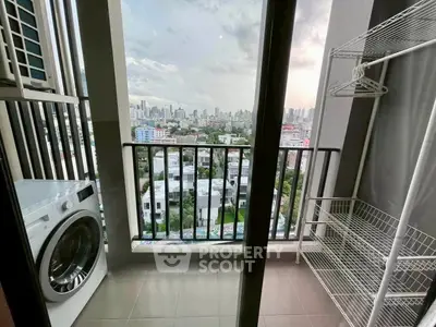 High-rise balcony with city view, featuring a washing machine and storage rack, perfect for urban living.