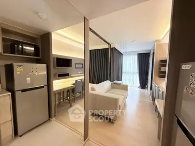 Modern open-plan living room with kitchen, featuring sleek design and natural light.