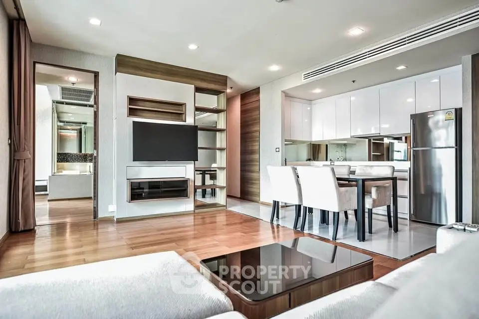 Spacious modern living room with open kitchen and elegant dining area in luxury apartment.