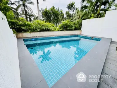 Luxurious private pool surrounded by lush greenery in a serene setting.