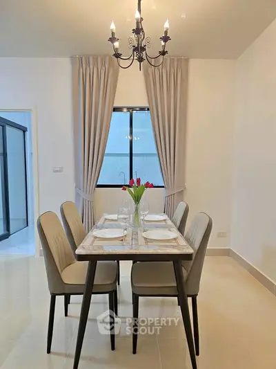 Elegant dining area with chandelier and modern decor in a stylish home.