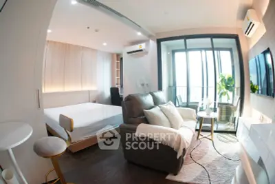 Modern studio apartment with cozy living area and balcony view
