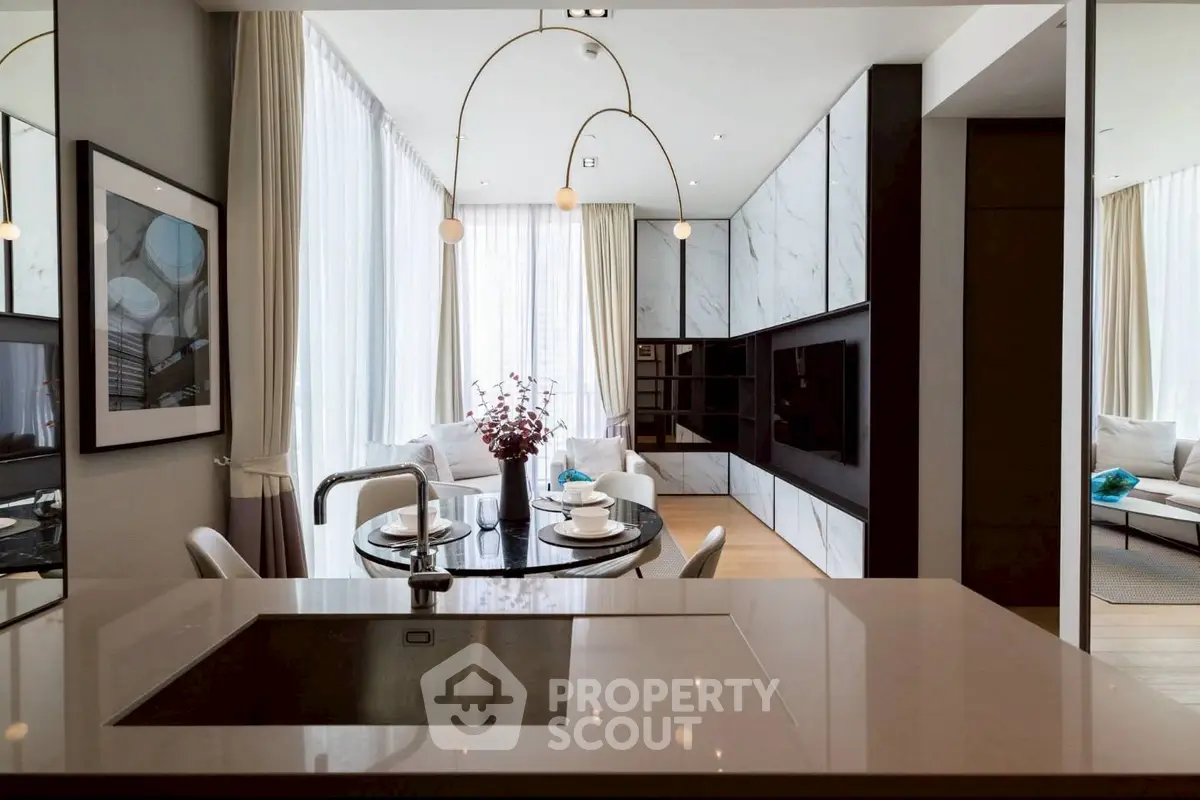 Luxurious modern living room with open kitchen and elegant dining area, featuring floor-to-ceiling windows.