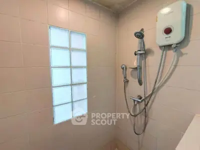 Modern bathroom with shower and water heater in tiled enclosure