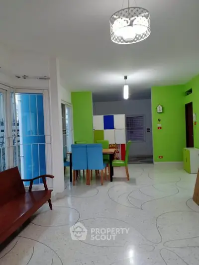 Spacious living room with vibrant green walls and modern dining area.