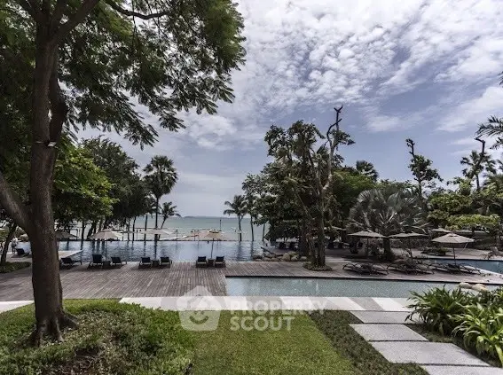 Luxurious beachfront pool with stunning ocean view and lush greenery.