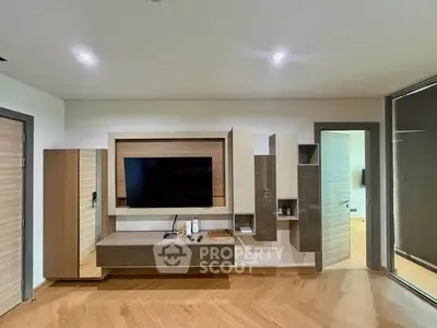 Modern living room with sleek TV unit and wooden flooring, showcasing contemporary interior design.
