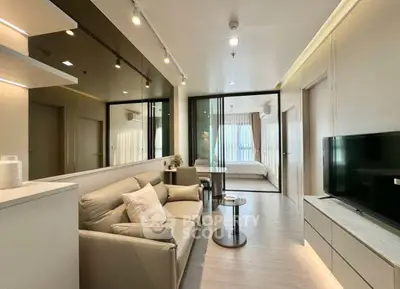 Modern living room with sleek design and open layout leading to bedroom