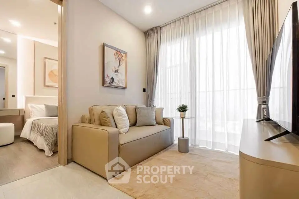 Modern living room with cozy sofa, large TV, and elegant decor in a bright apartment.