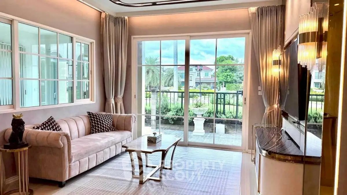 Luxurious living room with elegant decor and large windows offering a stunning garden view.