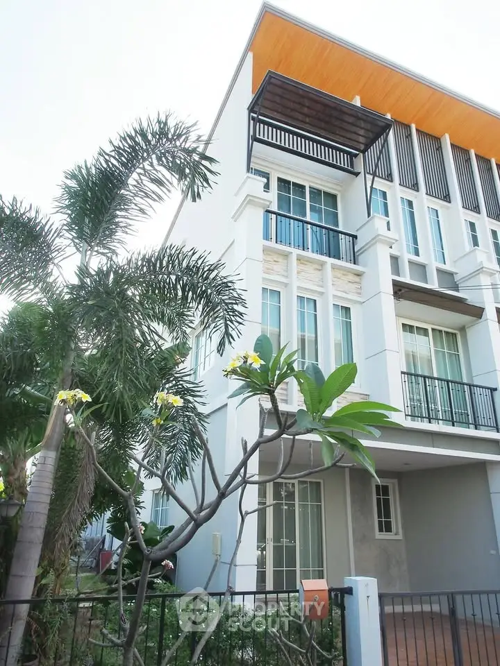 Modern multi-story building with stylish facade and lush greenery, perfect for urban living.