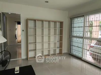 Spacious living room with large window and modern shelving unit