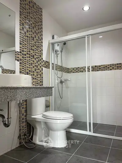 Modern bathroom with sleek shower enclosure and stylish tile accents.
