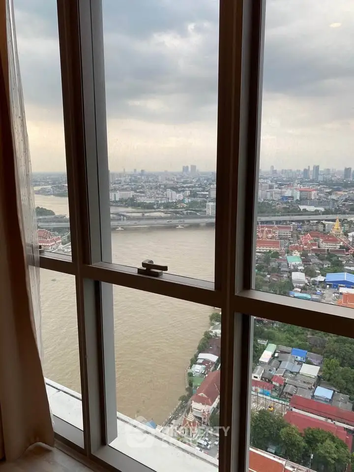 Stunning high-rise apartment view overlooking a river and cityscape, perfect for urban living.