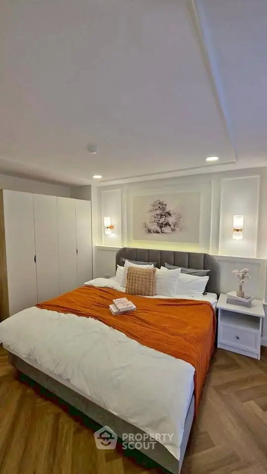 Cozy bedroom with modern decor and warm lighting, featuring a comfortable bed and stylish wardrobe.