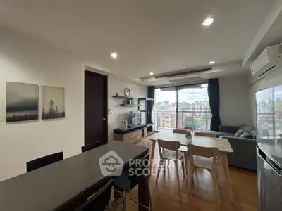 Spacious modern living room with dining area and city view, featuring sleek furniture and large windows.