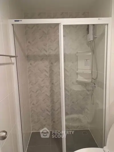 Modern bathroom with glass shower enclosure and stylish tile design.