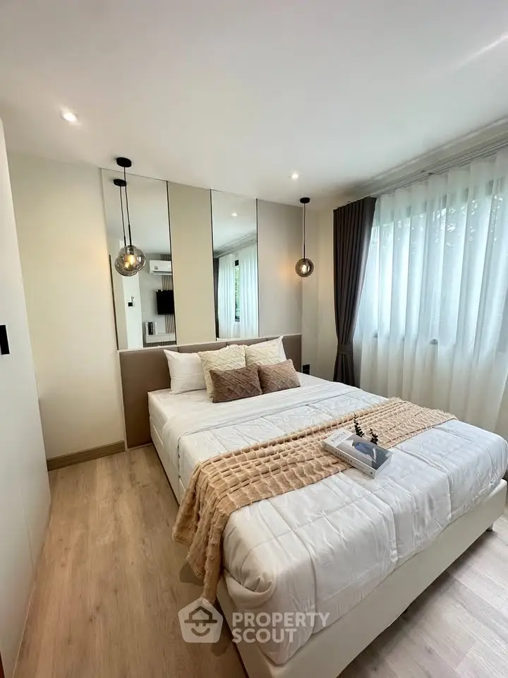 Elegant bedroom with modern decor, cozy bed, and ample natural light through large windows.