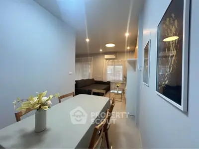 Modern dining area with elegant decor and cozy living room in open layout apartment