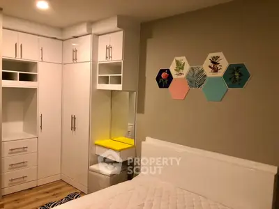 Modern bedroom with stylish white furniture and colorful wall art
