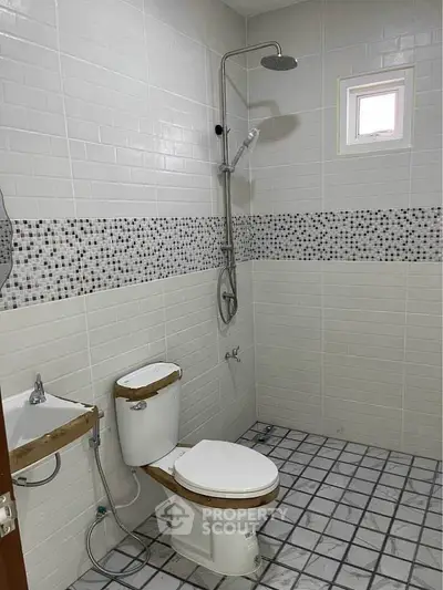 Modern bathroom with shower and tiled walls in real estate property.