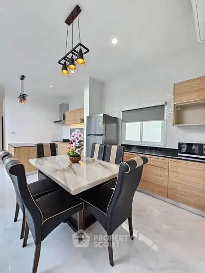 Modern kitchen with elegant dining area and stylish lighting fixtures