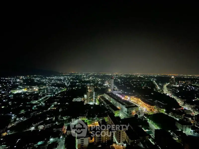 Stunning nighttime cityscape view from high-rise apartment balcony.