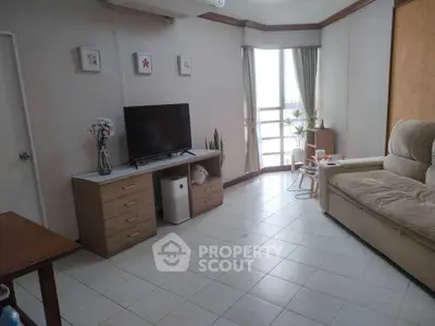 Cozy living room with natural light, modern decor, and comfortable seating in a stylish apartment.