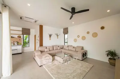 Spacious modern living room with beige sectional sofa, ceiling fan, and stylish decor in a bright open layout.