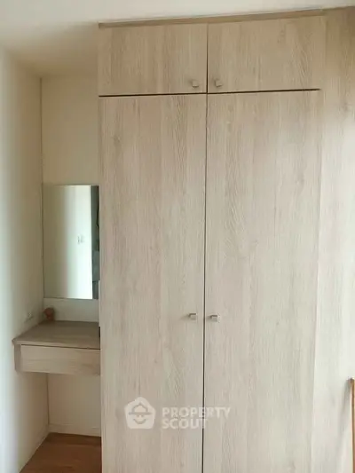 Spacious wooden wardrobe with built-in vanity in modern apartment