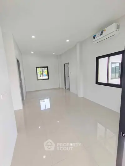 Spacious modern living room with large windows and air conditioning