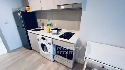 Modern compact kitchen with washing machine and sleek appliances