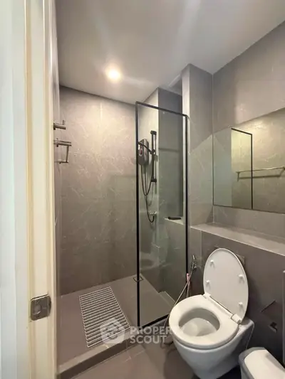 Modern bathroom with glass shower and sleek design in contemporary apartment.