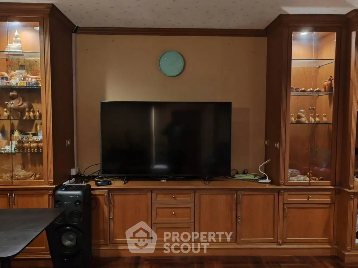 Elegant living room with wooden cabinetry and modern TV setup