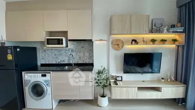 Modern kitchen and living area with sleek cabinetry and appliances