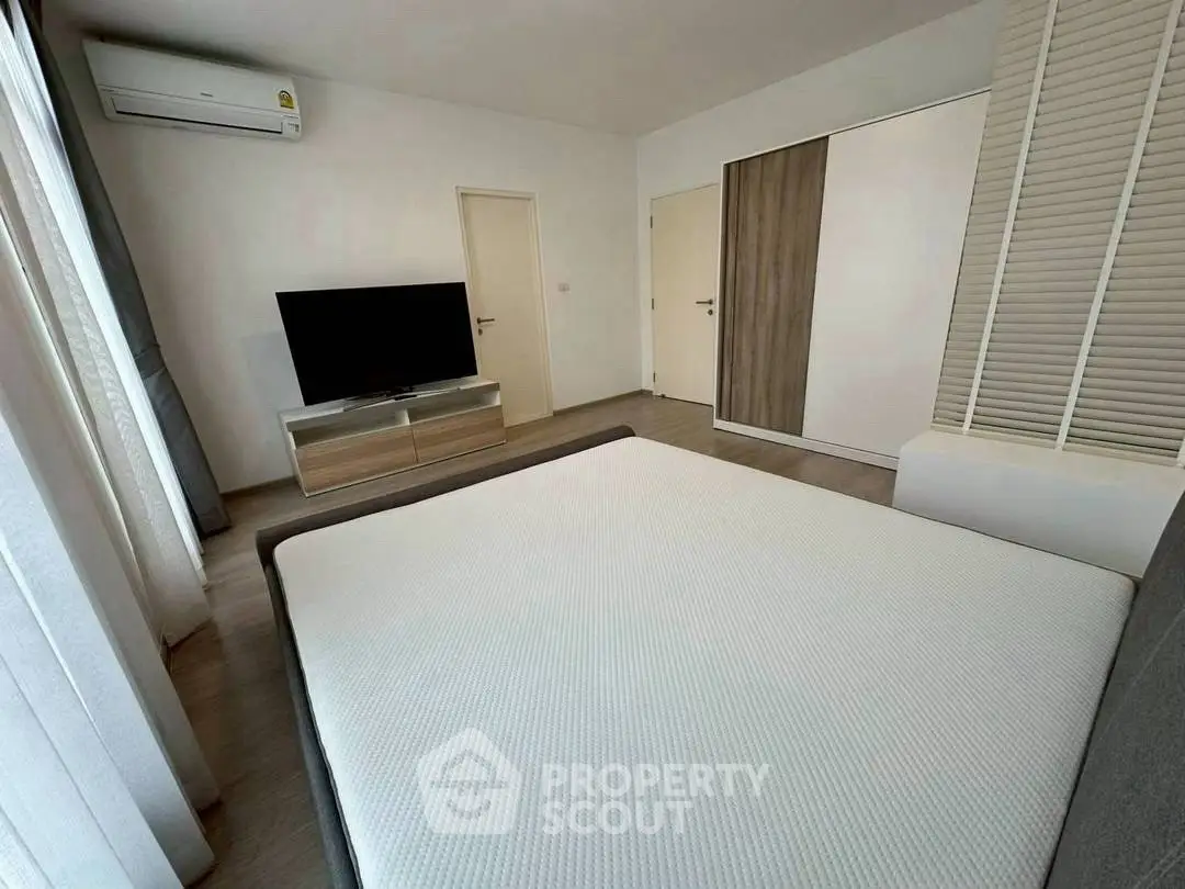 Spacious modern bedroom with large windows and sleek furniture