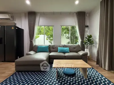 Modern living room with stylish decor and large windows overlooking greenery.
