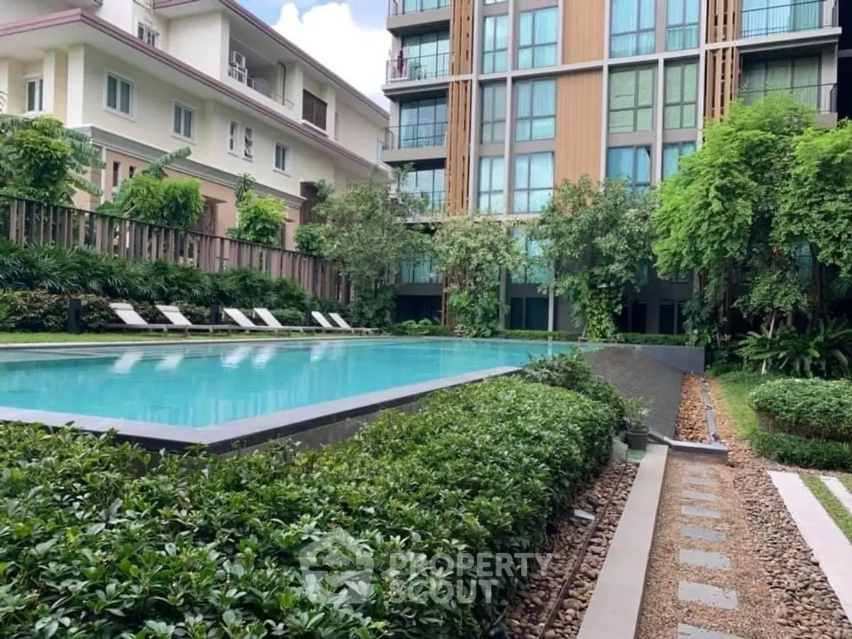 Luxurious apartment complex with serene pool and lush greenery