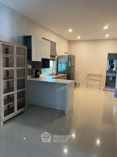 Spacious modern kitchen with sleek cabinetry and ample natural light, perfect for culinary enthusiasts.