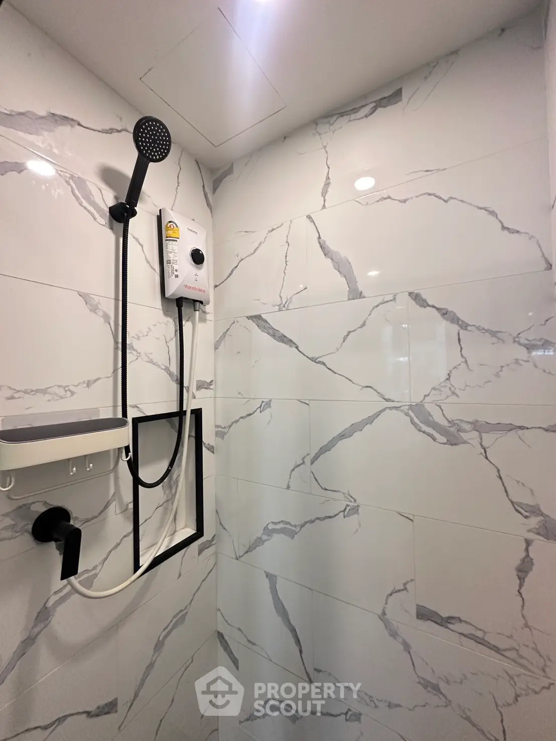Modern bathroom with sleek marble tiles and high-end shower fixtures.