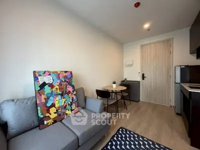 Modern living room with cozy sofa and vibrant artwork, open kitchen layout, and stylish dining area.