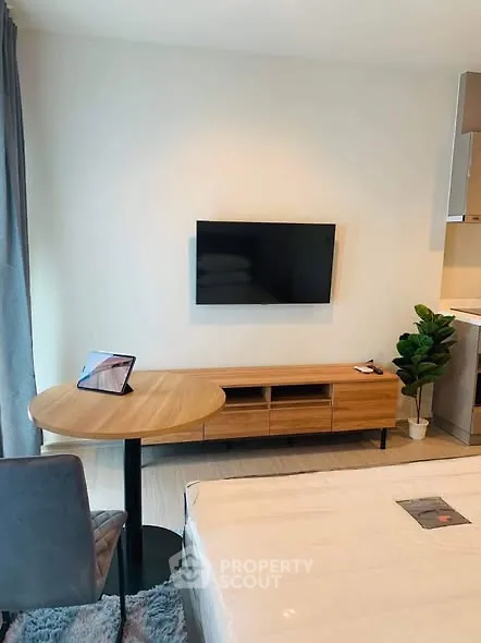 Modern studio apartment with sleek TV setup and cozy furnishings.