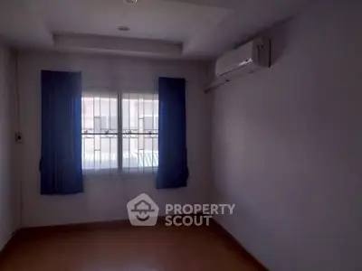 Spacious unfurnished room with air conditioning and large window, perfect for customization.