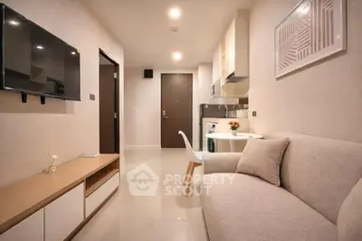 Modern living room with sleek furniture and wall-mounted TV in a cozy apartment.