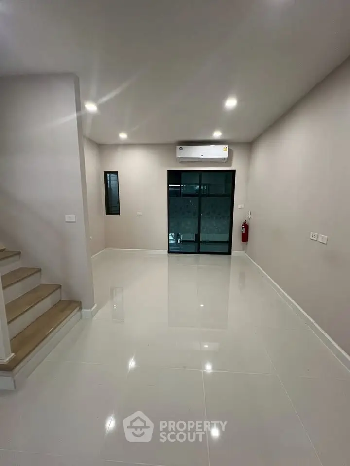 Spacious modern living room with sleek flooring and ambient lighting